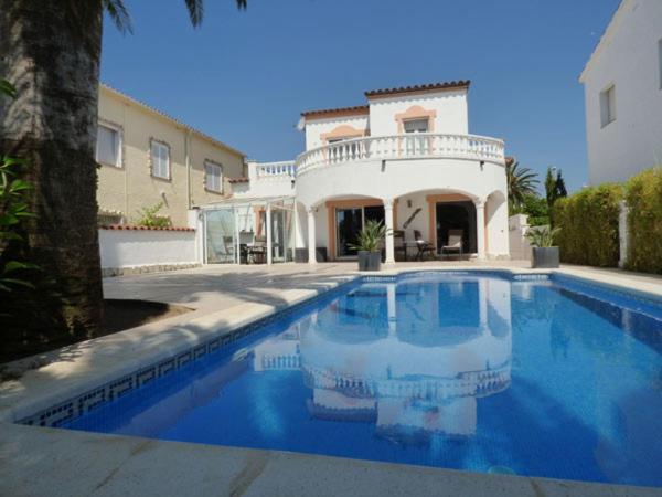 a large swimming pool in front of a house at Cap Ras in Empuriabrava