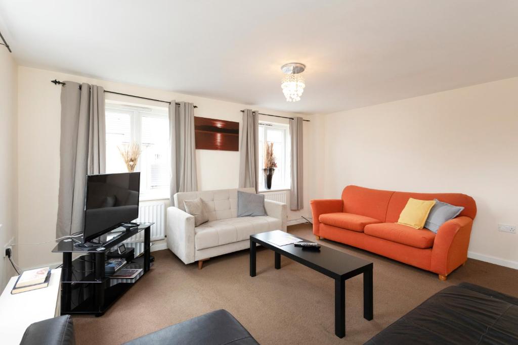 ein Wohnzimmer mit einem Sofa und einem TV in der Unterkunft Hamber in Leicester