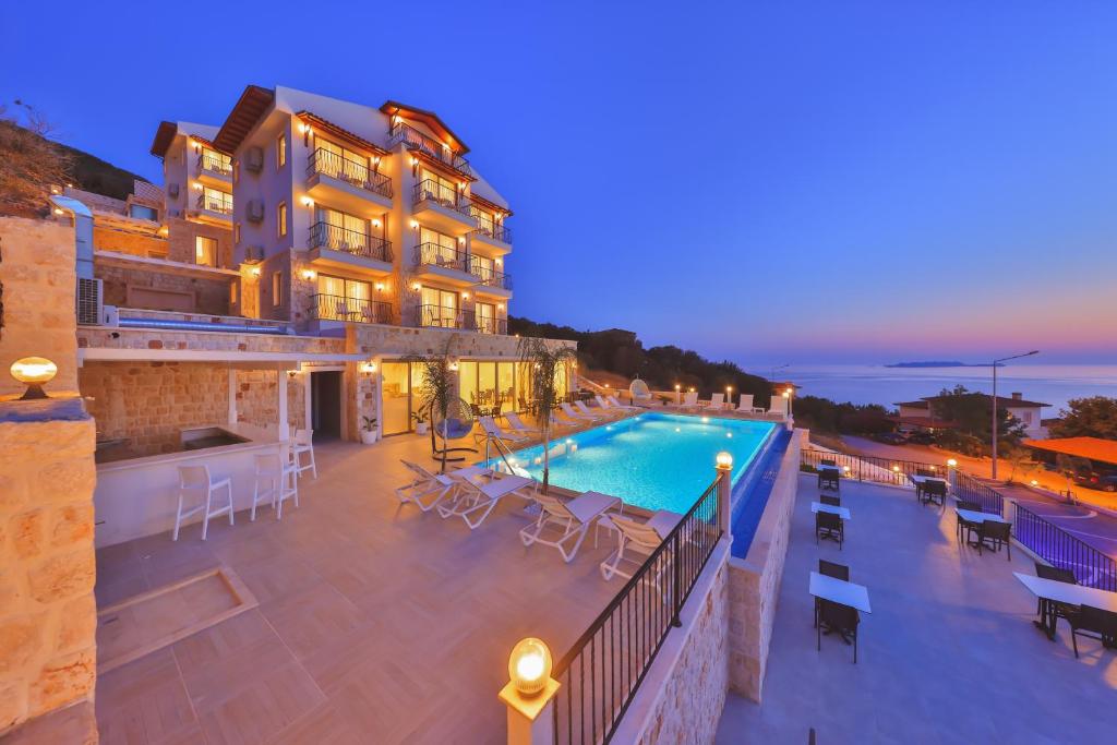 a hotel with a swimming pool at night at Hilaris Hotel in Kas