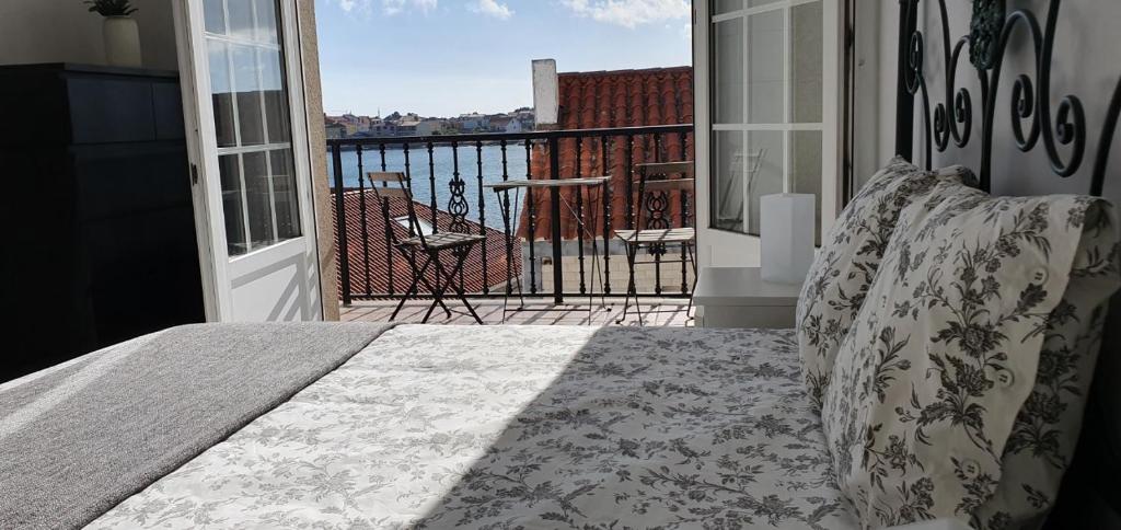 sypialnia z łóżkiem i balkonem z widokiem w obiekcie APARTEMENTOS PASEO DE LORDELO - 2 Derecha w mieście O Grove
