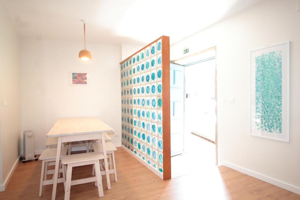 a room with a table and a stool next to a door at Casa S. Miguel 6 in Porto