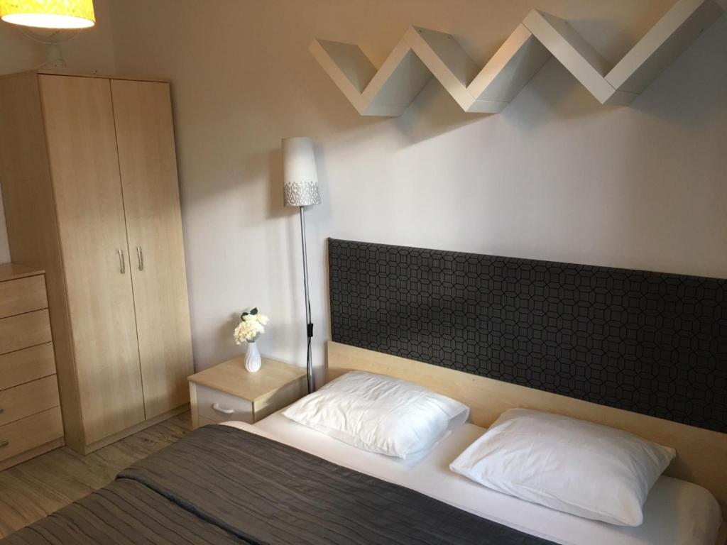 un dormitorio con una cama con dos almohadas blancas en Apartament Stanczyka 2, en Varsovia