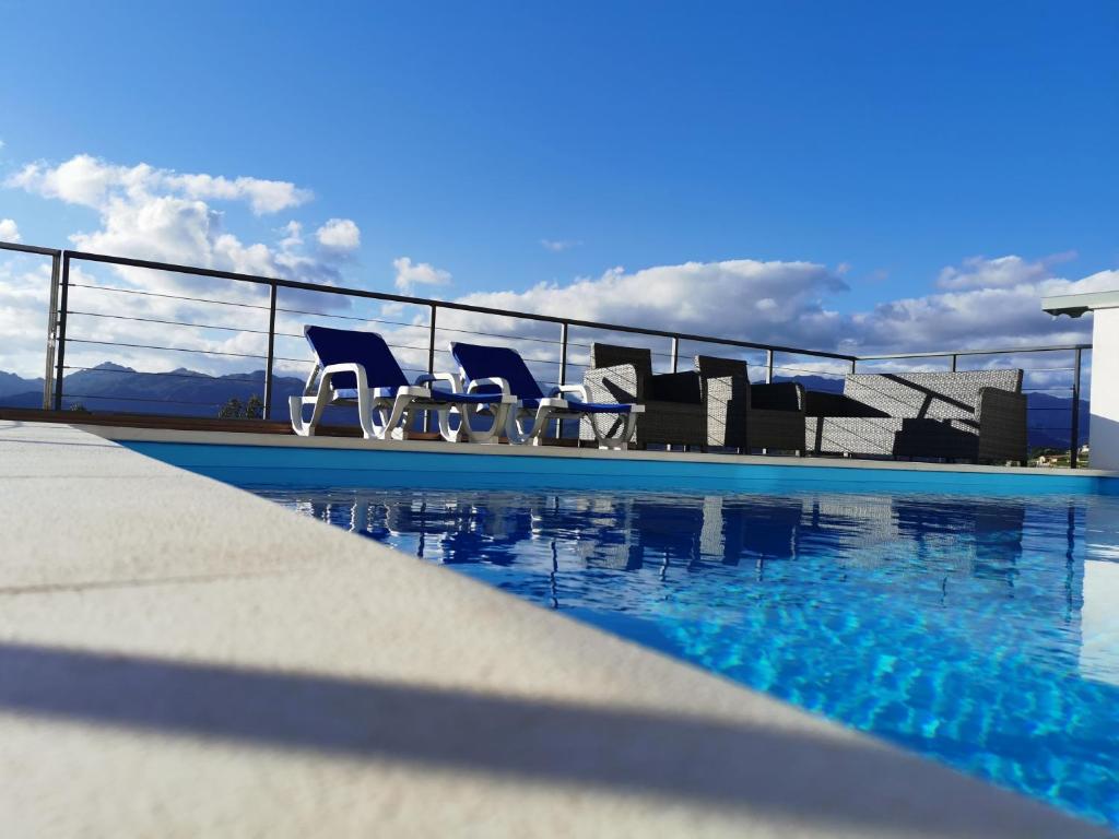 eine Gruppe von Stühlen neben einem Swimmingpool in der Unterkunft Casa Miradouro in Cova