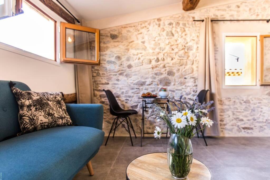 ein Wohnzimmer mit einem blauen Sofa und einem Tisch mit Blumen in der Unterkunft Charming Appartement III in Antibes