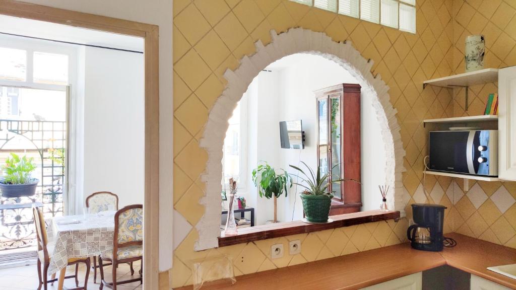 a kitchen with an arched window and a table with chairs at Appartement 3 pièces ultra centre nice-ville in Nice