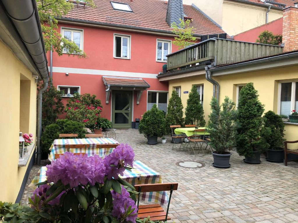 een binnenplaats van een huis met een tafel en paarse bloemen bij Ferienwohnung "Ankerplatz" mit 2 Schlafzimmern in Rheinsberg
