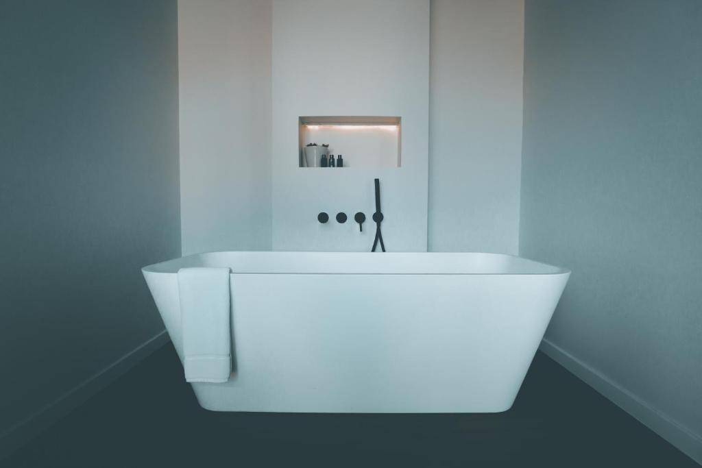 a white bath tub in a bathroom with blue walls at Nocturne in Bruges