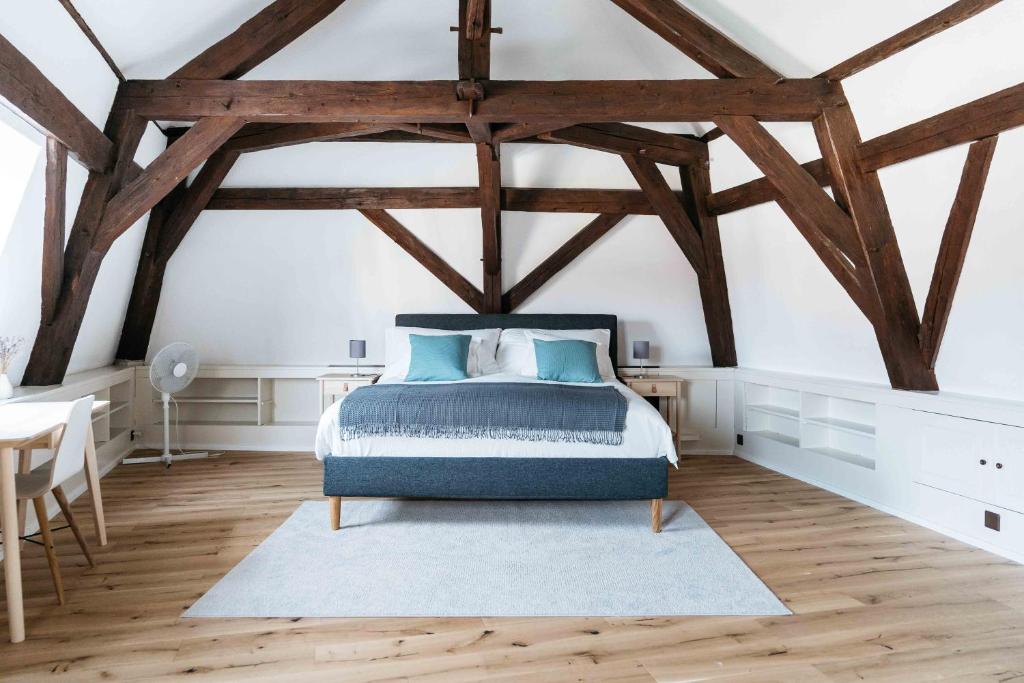 una camera con letto in una stanza con travi in legno di Hemma a Aubonne