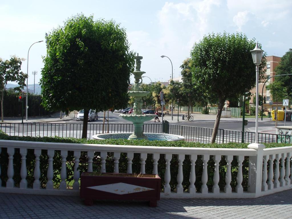 a white fence with a fountain in the middle of a street at Cordoba Tourist Apartments in Córdoba