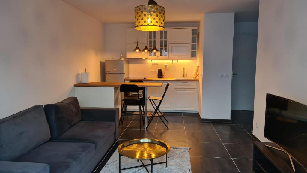 a living room and kitchen with a couch and a table at Appartement Plage Prado/Vélodrome in Marseille