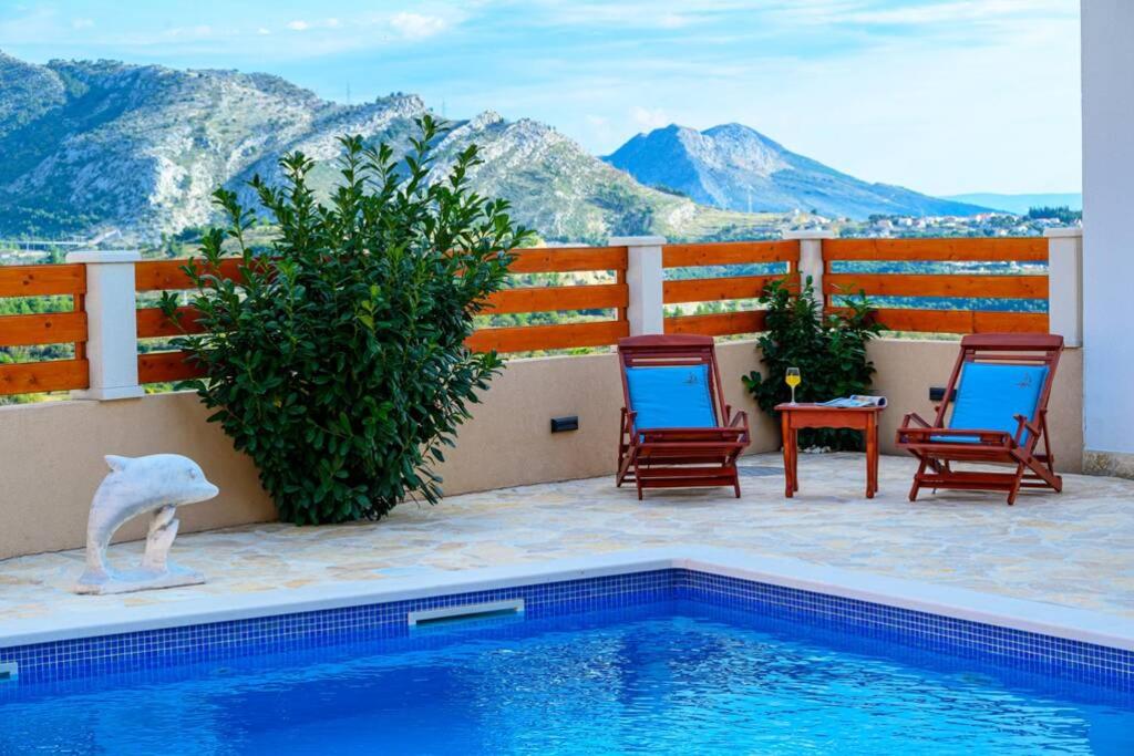 una piscina con 2 sillas y un pájaro en un patio en NEW! Apartment with private pool near Split, en Solin