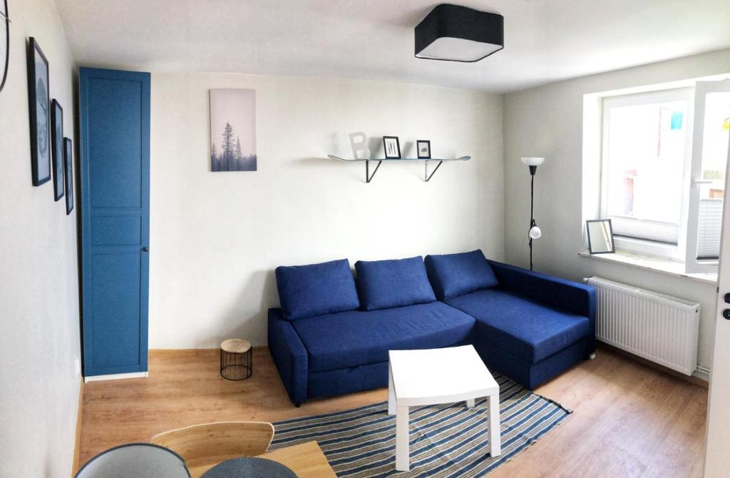 sala de estar con sofá azul y mesa en Studio Kruhelska, en Przemyśl