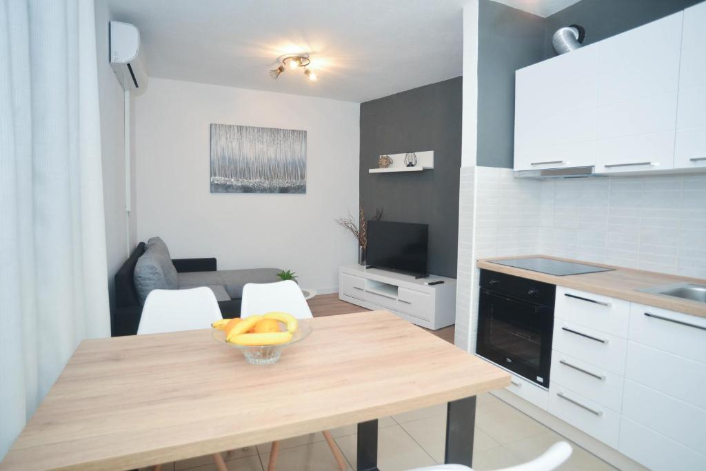 a kitchen with a table with a bowl of fruit on it at Apartment Ante in Biograd na Moru