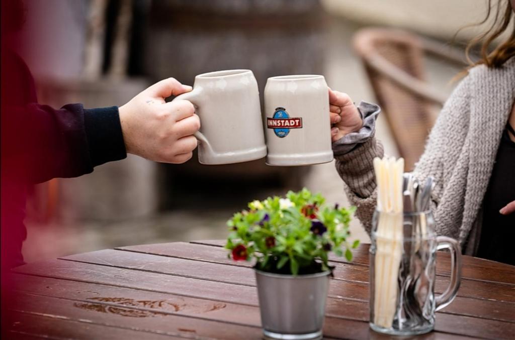 dos personas sosteniendo tazas de café en una mesa en Landgasthof Bayerwald, en Böbrach
