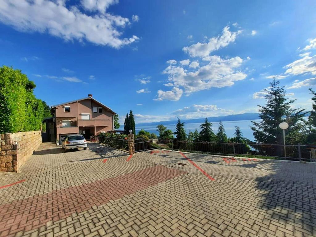 eine Auffahrt mit einem Haus und einem Auto geparkt in der Unterkunft Nate Apartments in Ohrid