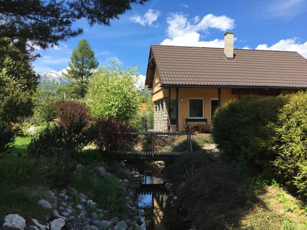 a house with a bridge over a stream at Domček Ami in Stará Lesná