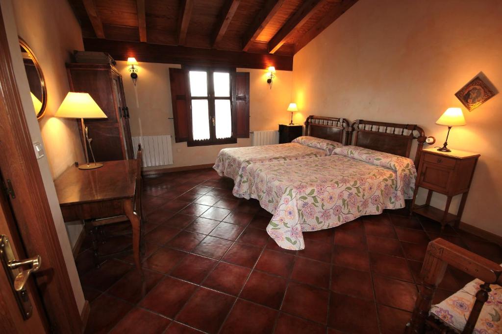 a bedroom with a bed and a table and chairs at Casa Rural El Meson in Briones