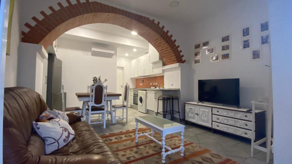 uma sala de estar com um sofá, uma mesa e uma cozinha em Coração da Vila em Alcochete