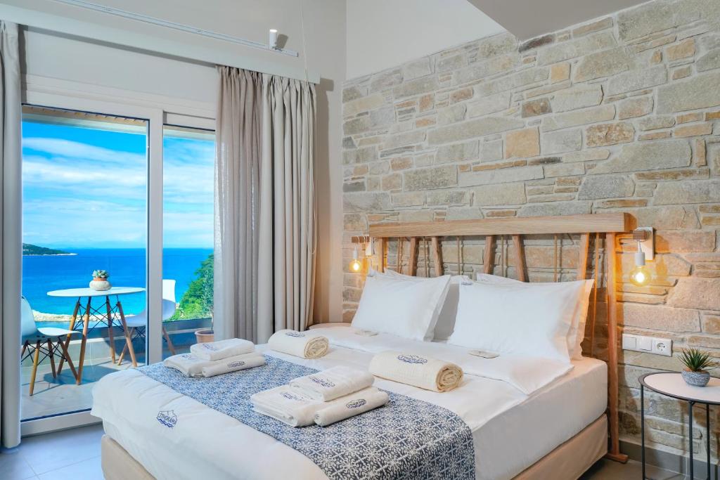 スカラ・ポタミアスにあるLithorama Boutique Suitesの海の景色を望むベッドルーム1室(キングサイズベッド1台付)