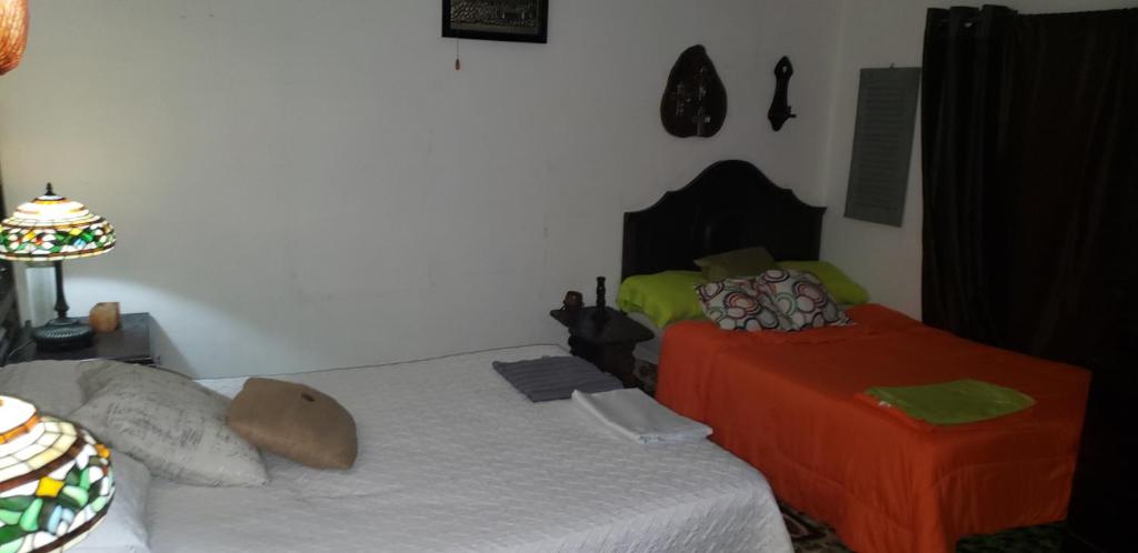sypialnia z 2 łóżkami i lampką w obiekcie Mendoza’s Guest House w mieście Santa Ana