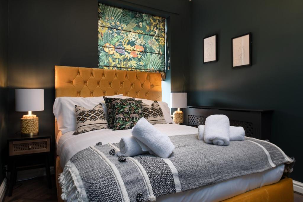 a bedroom with a bed with two stuffed animals on it at Lonsdale house by Orenda-Luxe in Llandudno