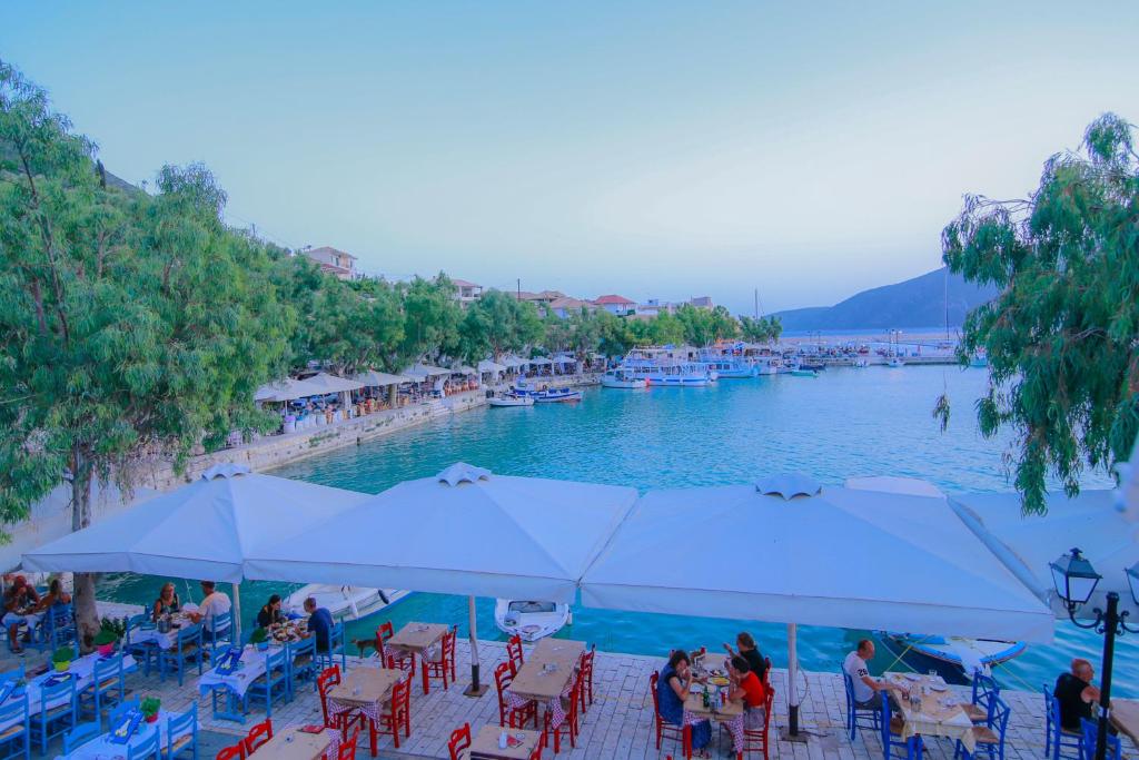 a group of people sitting in chairs around a pool at Orfeas Studios in Vasiliki