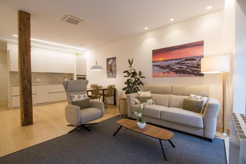 uma sala de estar com um sofá e duas cadeiras e uma mesa em ATSEGIN apartment climatización -Opción a parking- em San Sebastián