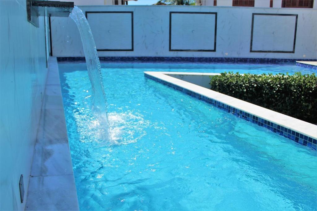 a blue swimming pool with a water fountain at apartamento 2 quartos em Porto segur BA in Porto Seguro