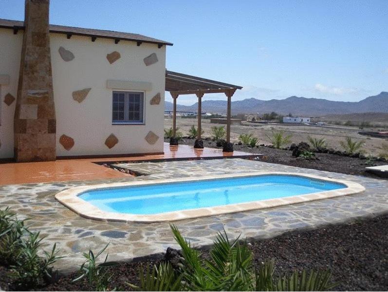 a swimming pool in front of a house at Villas La Fuentita in Gran Tarajal