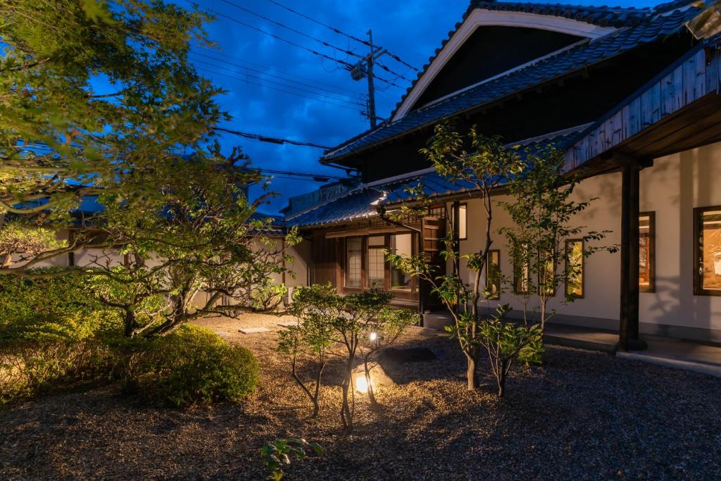 富田林市にあるヘリテージ大阪の庭の木々と夜の家