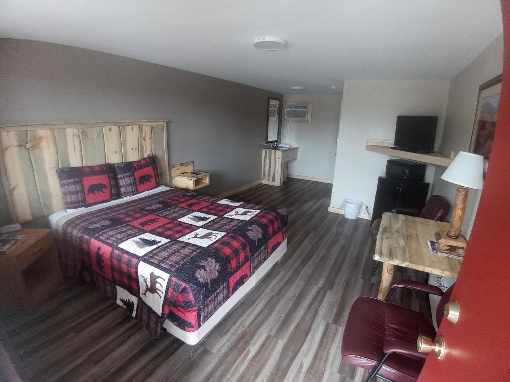 a bedroom with a bed and a wooden floor at Aneth Lodge Budget 6 in Cortez