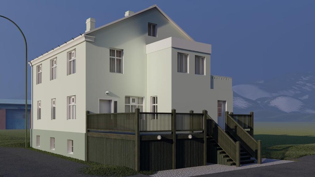 ein weißes Haus mit einem Balkon in der Unterkunft Riverside Hostel in Blönduós