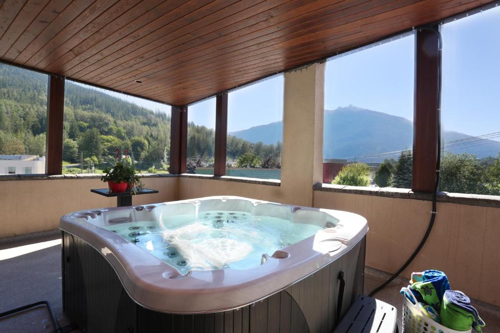 a jacuzzi tub in a room with windows at Lily glacier suite at silver bear condos in Revelstoke