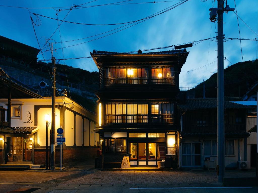 a building with a lit up facade at night at LAMP Iki in Iki