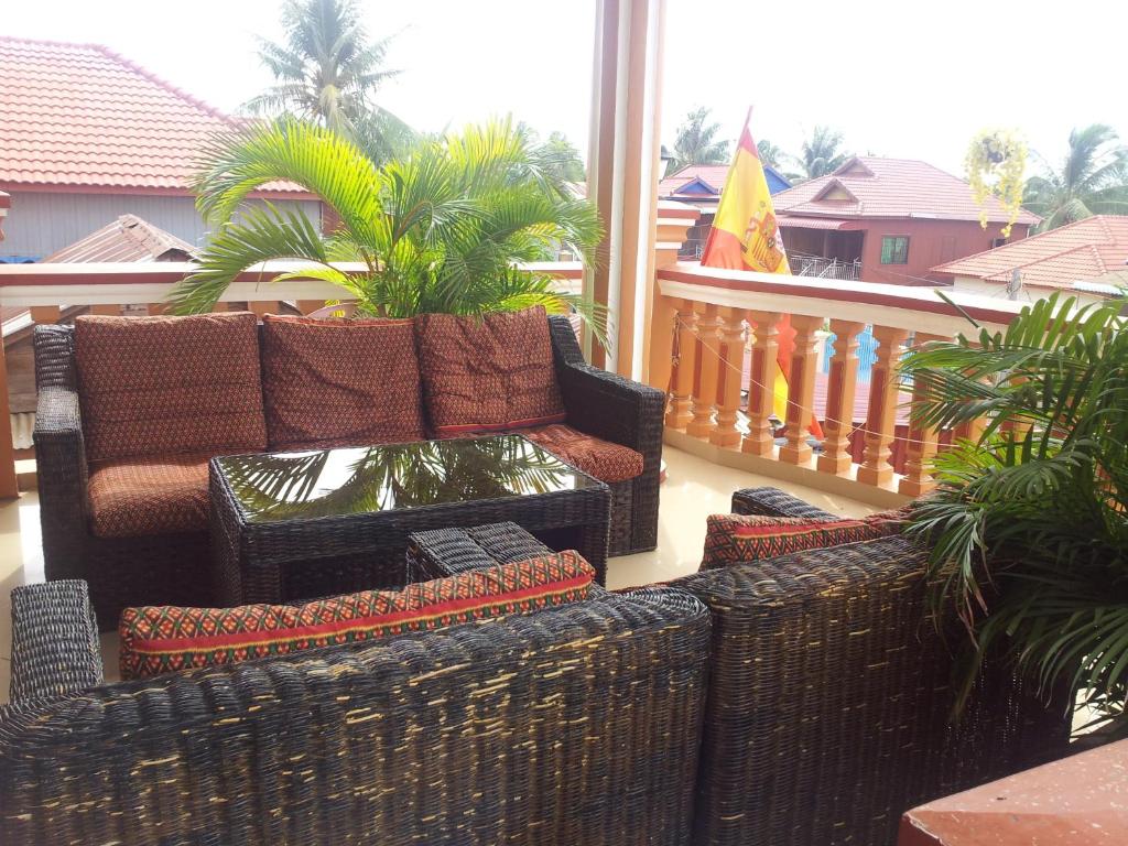 a living room with a couch and chairs on a balcony at Javier Guesthouse in Tbeng Meanchey