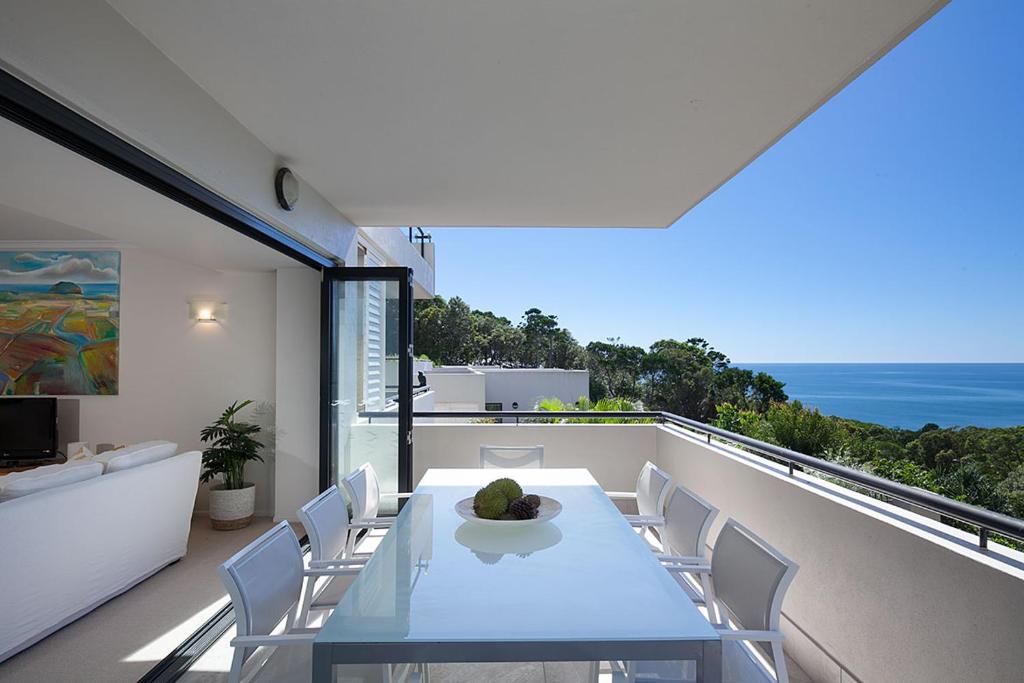 a dining room with a table and chairs on a balcony at Papillon Coolum in Coolum Beach