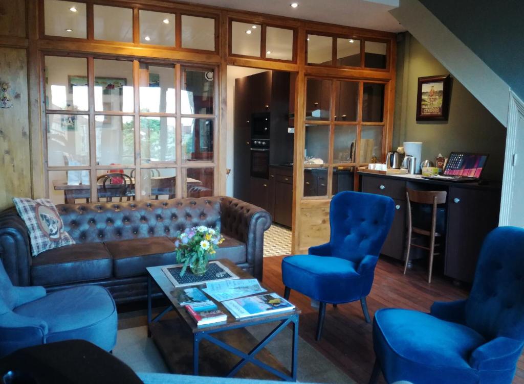 a living room with a couch and blue chairs at Gîte les 4 Vents in Pradelles