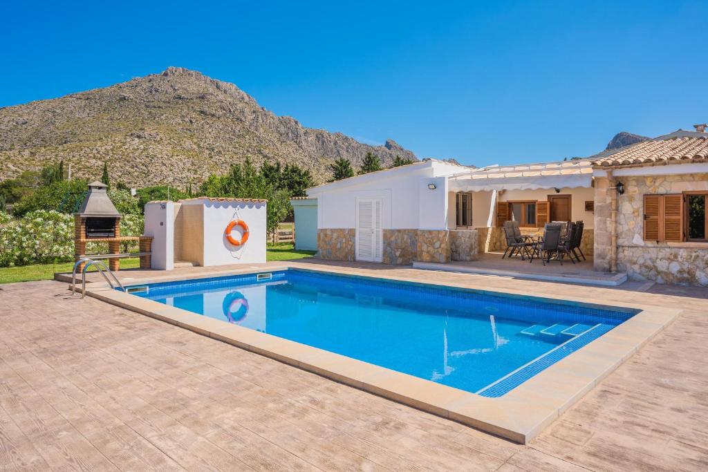 una piscina en un patio con una casa en Villa Can Serra, en Puerto Pollensa