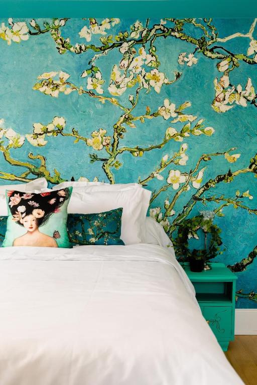 une chambre avec un lit blanc avec un mur bleu dans l'établissement Maison 1934 - Colmar Gare & Parking gratuit, à Colmar