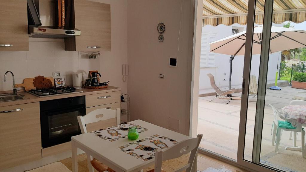 a kitchen with a table and a dining room with an umbrella at Casa Mare Ognina in Ognina