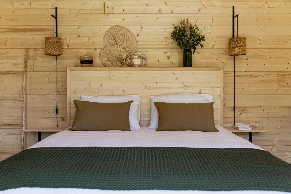 a bedroom with a large bed with two pillows at Les Lodges de Malbrough in Aire-sur-la-Lys