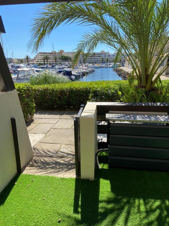 un banc assis sur l'herbe à côté d'un port de plaisance dans l'établissement Purple Secret Naturiste, au Cap d'Agde