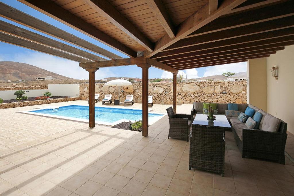 a patio with a table and chairs and a pool at Casa Rural Teberite in Tuineje