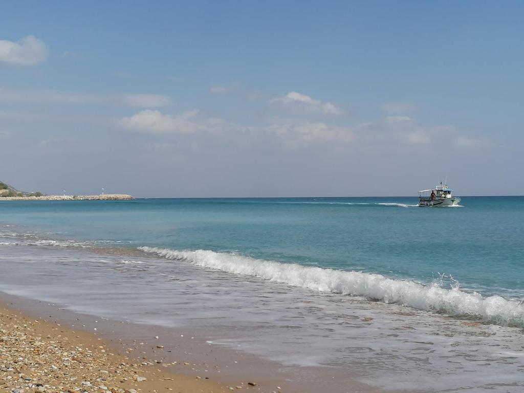 een strand met een boot in het water bij Studio apartment 1, Komi Beach in Kómi