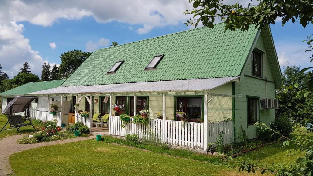 a green house with a green roof at Aare kodumajutus in Tammiku