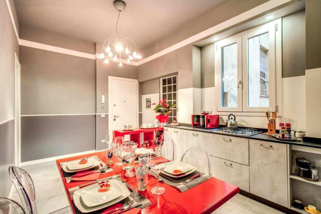 - une cuisine avec une table et des chaises rouges dans la chambre dans l'établissement Original House in Trastevere, à Rome