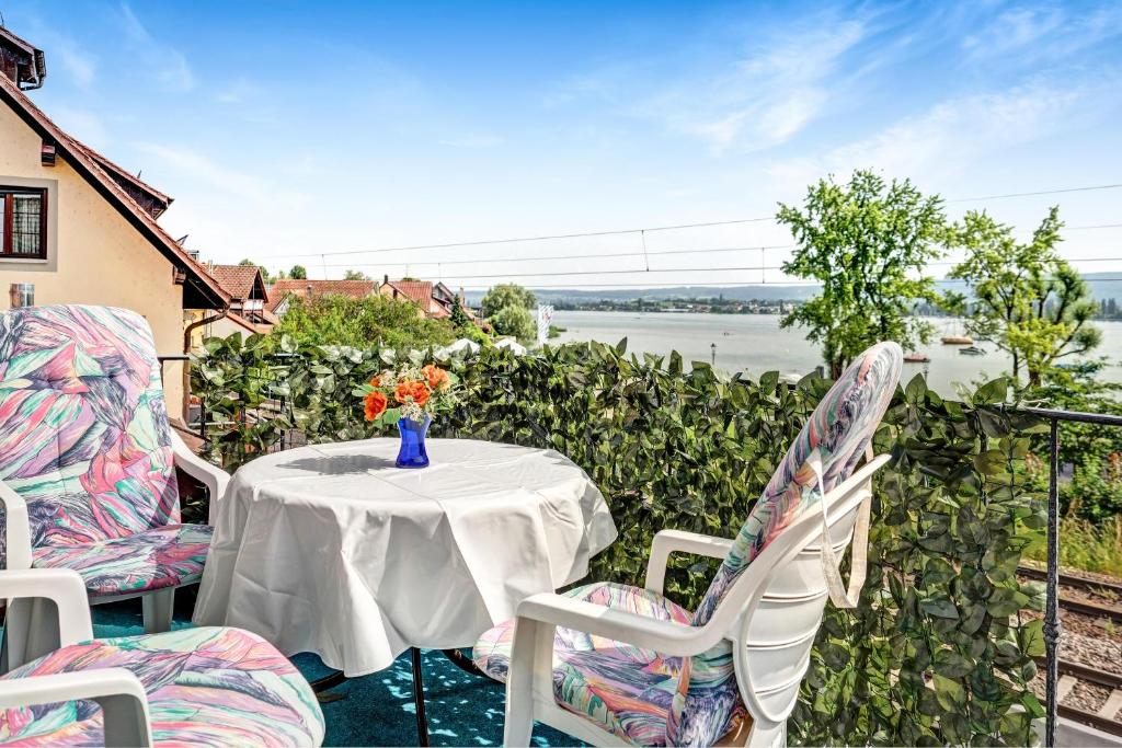 a table with a vase of flowers on a balcony at Reichenaublick in Allensbach