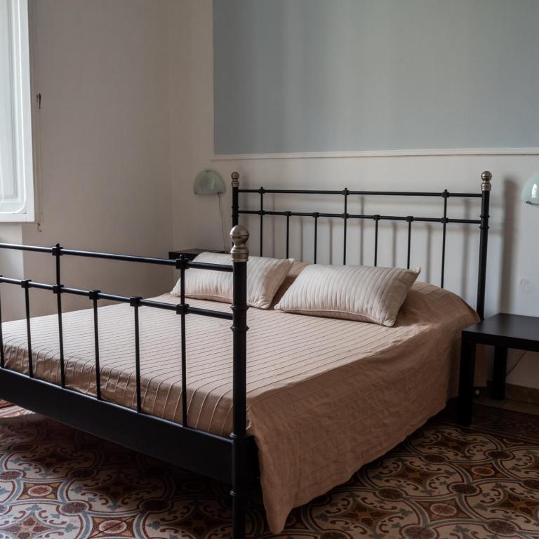 a bed in a bedroom with a black frame at Arena Alfieri B&B in Livorno