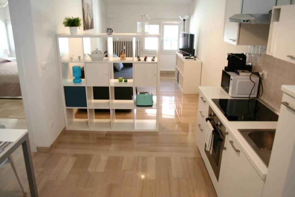 una pequeña cocina con armarios blancos y una cocina en Casa Palladio S, en Vicenza