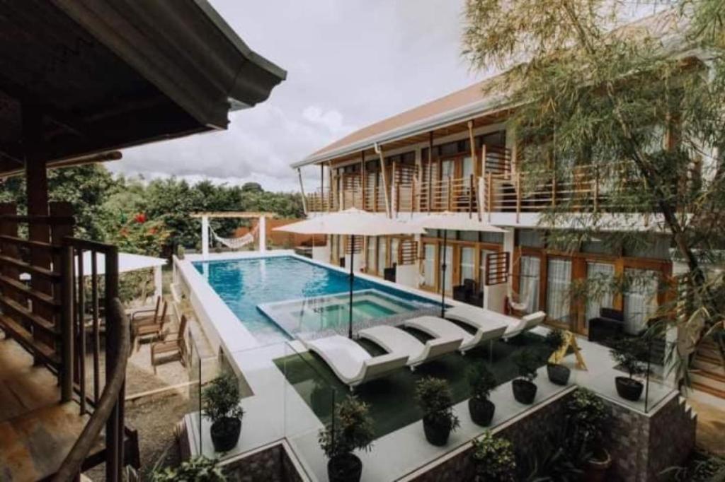 a pool in front of a building with a house at Ananda Resort in Panglao